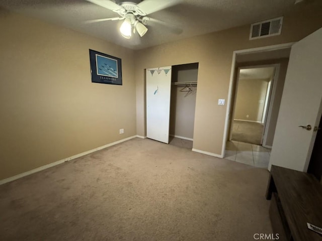 unfurnished bedroom with carpet floors, ceiling fan, and a closet