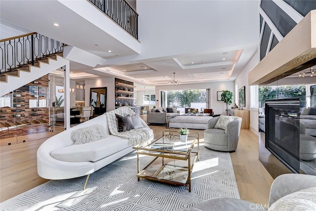 living room featuring a towering ceiling, wood-type flooring, and a tray ceiling