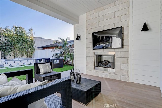 view of patio with an outdoor living space with a fireplace