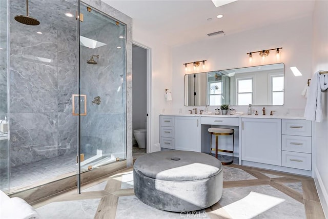 bathroom featuring walk in shower, vanity, and toilet