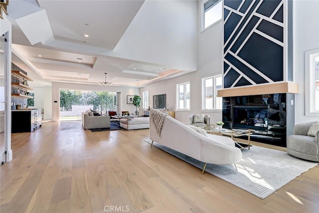 living room with a tray ceiling and light hardwood / wood-style floors