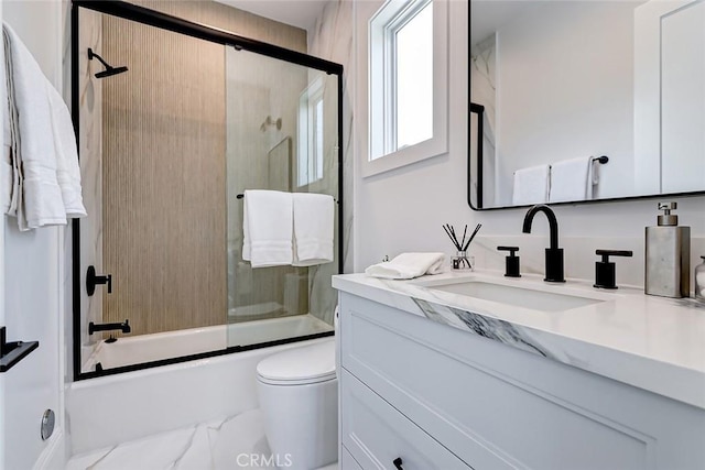 full bathroom with vanity, shower / bath combination with glass door, and toilet