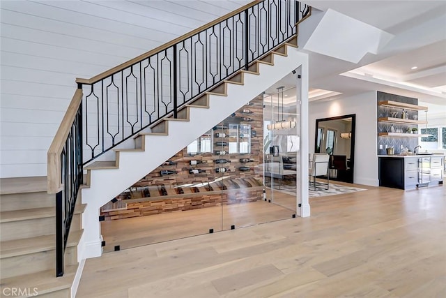 stairway featuring hardwood / wood-style flooring and a tray ceiling