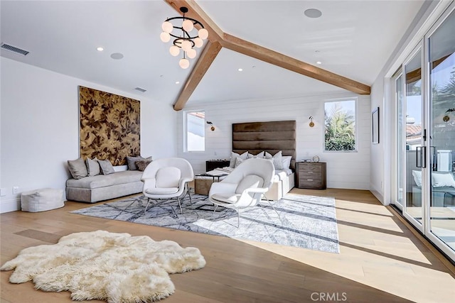 bedroom featuring access to exterior, lofted ceiling with beams, and light wood-type flooring