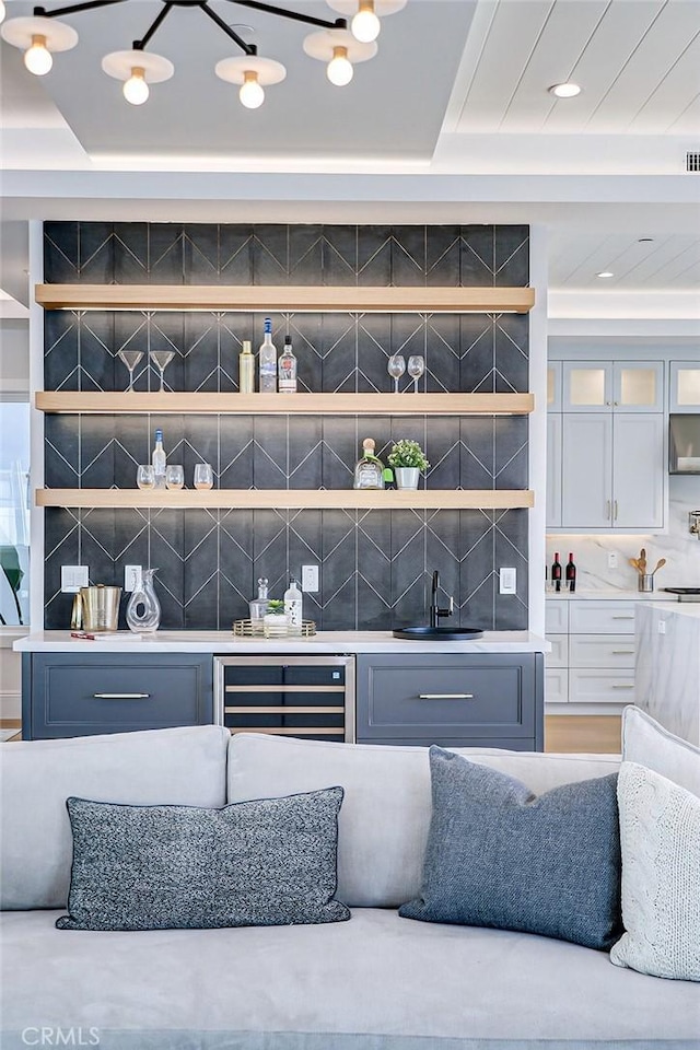 bar with wine cooler, sink, and backsplash