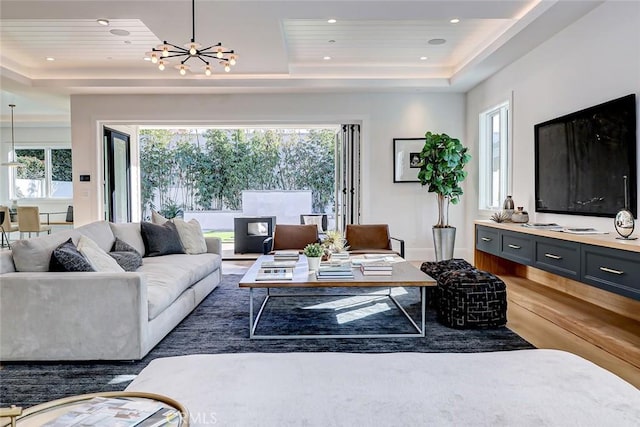 living room with dark hardwood / wood-style flooring, a notable chandelier, wood ceiling, and a tray ceiling