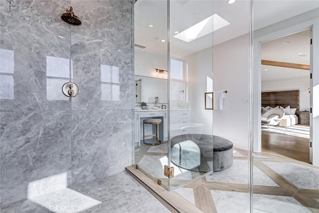 bathroom with a shower with door, vanity, and a skylight