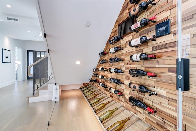 wine area featuring wood-type flooring and wooden walls