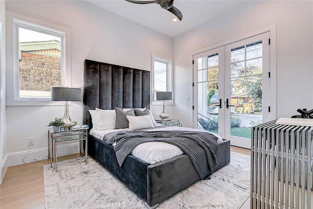 bedroom with access to exterior, wood-type flooring, french doors, and ceiling fan