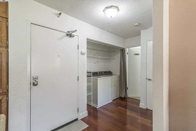 corridor with dark hardwood / wood-style floors, a textured ceiling, and independent washer and dryer