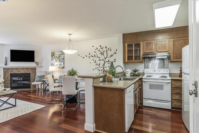 kitchen with sink, decorative light fixtures, dark hardwood / wood-style flooring, kitchen peninsula, and white appliances