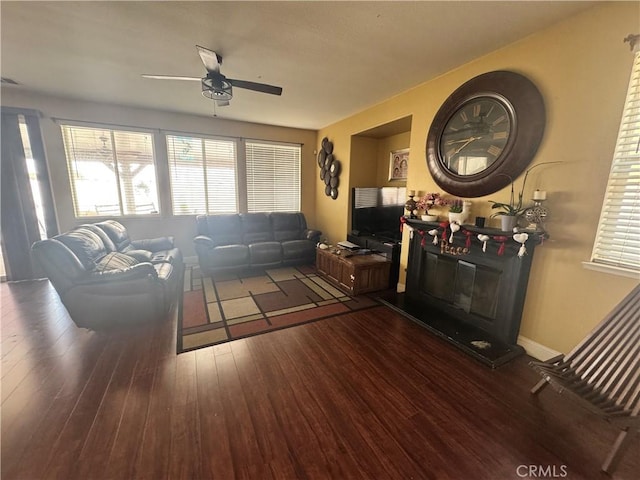 living room featuring dark hardwood / wood-style flooring and ceiling fan