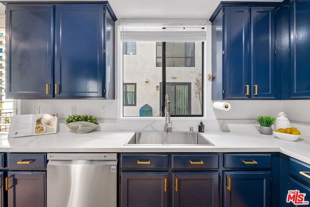 kitchen featuring dishwasher, sink, and blue cabinetry