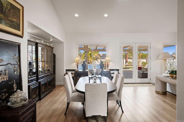 dining area featuring french doors, vaulted ceiling, and light hardwood / wood-style flooring