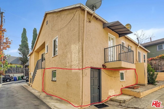 view of side of home featuring a balcony