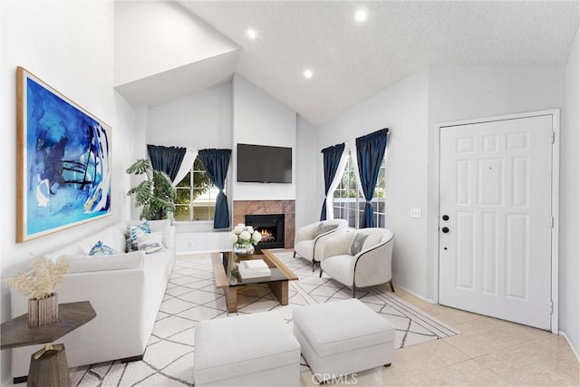 living room featuring a tile fireplace, light tile patterned floors, a textured ceiling, and high vaulted ceiling