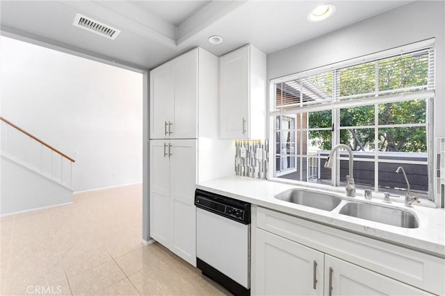 kitchen featuring white dishwasher, sink, white cabinetry, and light tile patterned floors