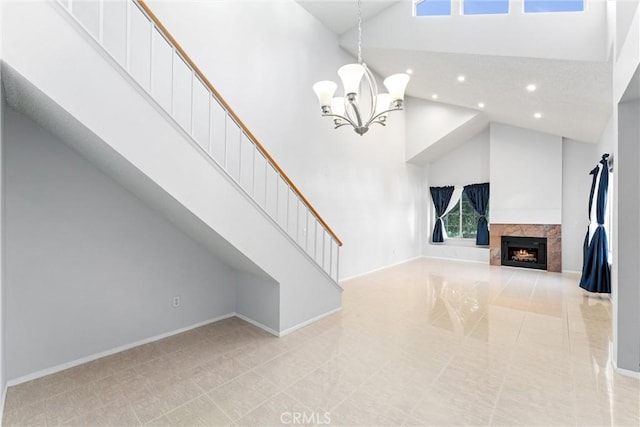 unfurnished living room with an inviting chandelier, a premium fireplace, and high vaulted ceiling