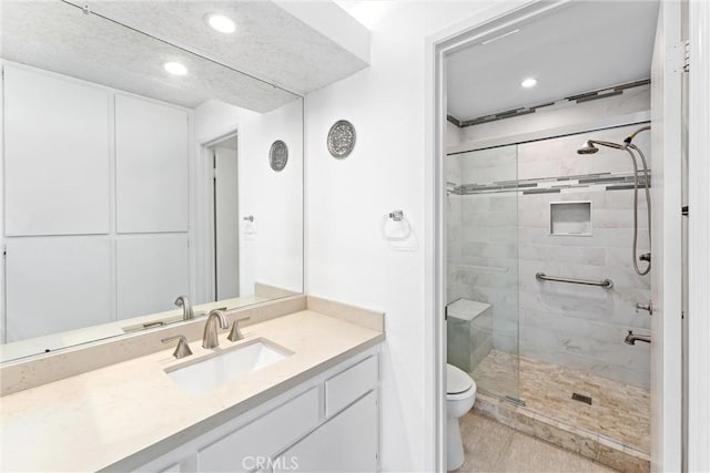 bathroom with an enclosed shower, vanity, and toilet