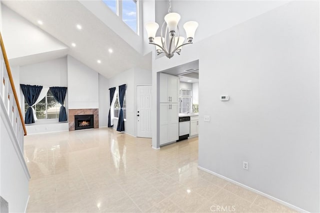 dining room featuring a premium fireplace, a chandelier, and high vaulted ceiling