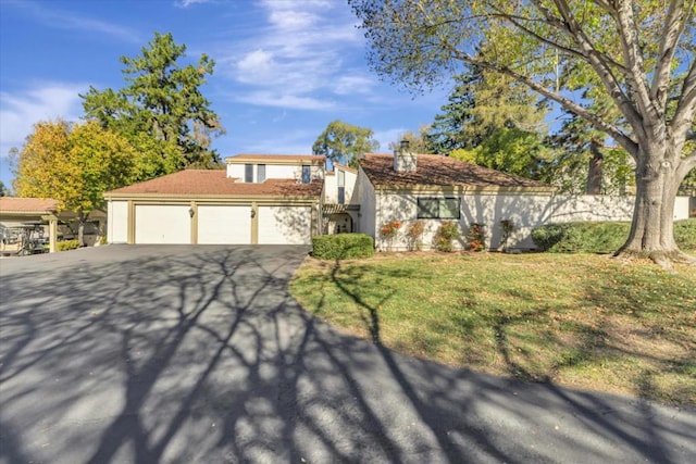 view of front of home with a garage and a front lawn