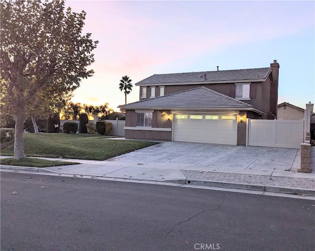 view of front facade with a garage and a lawn