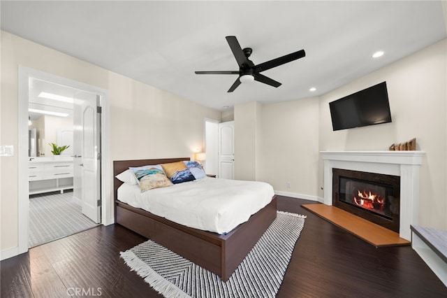 bedroom with dark wood-type flooring, ceiling fan, and ensuite bath