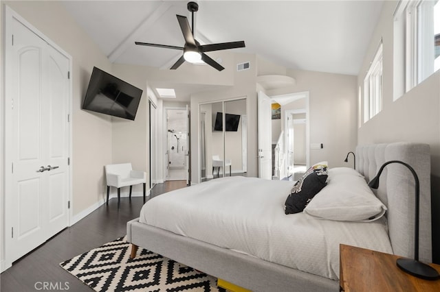 bedroom with ceiling fan, dark hardwood / wood-style flooring, vaulted ceiling, and ensuite bath