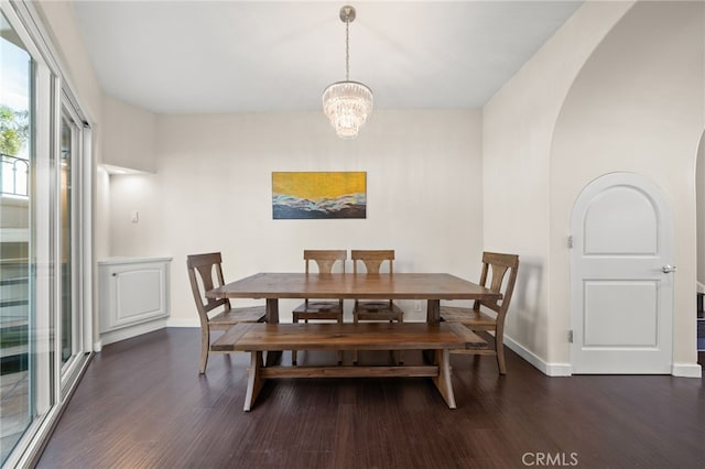 dining space featuring dark hardwood / wood-style flooring and an inviting chandelier