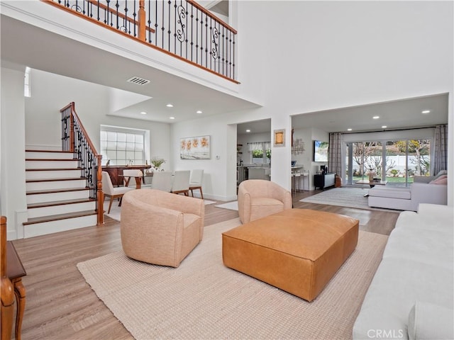 living room with light hardwood / wood-style flooring and a high ceiling