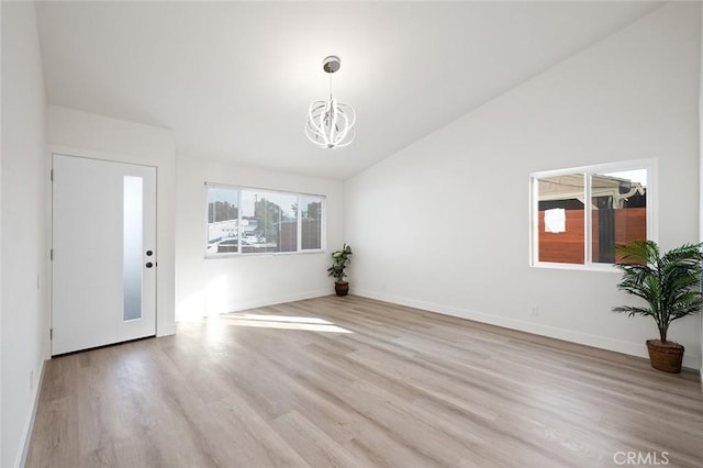 interior space with a chandelier, light hardwood / wood-style floors, and vaulted ceiling