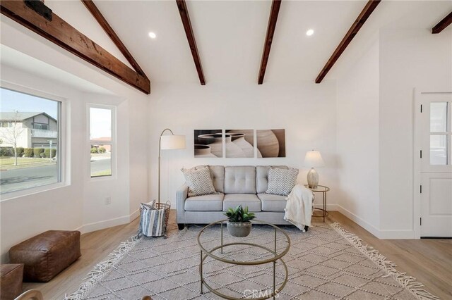 living room featuring light hardwood / wood-style floors and vaulted ceiling with beams