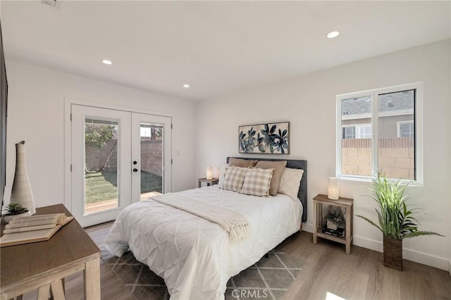 bedroom featuring access to exterior, wood-type flooring, and french doors