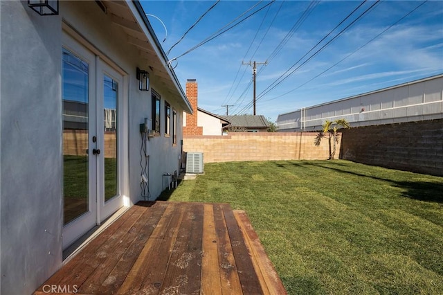 view of yard with cooling unit, french doors, fence, and a deck