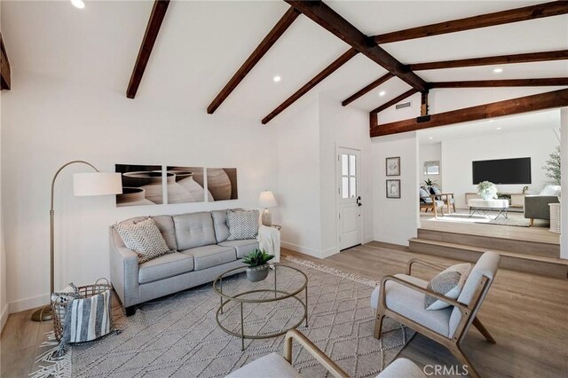 living room with lofted ceiling with beams and light wood-type flooring