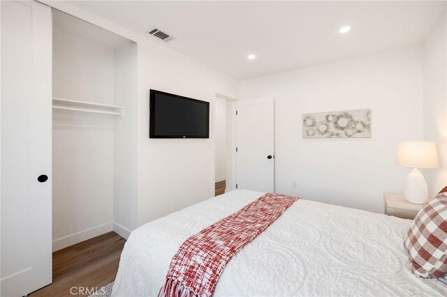 bedroom with wood-type flooring and a closet