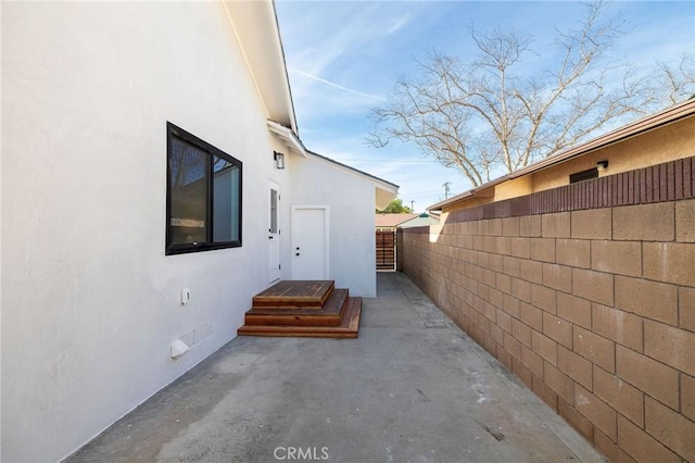 view of home's exterior with a patio area, fence, and stucco siding