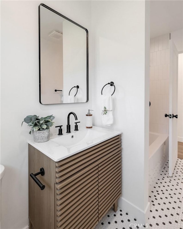 full bath with a washtub, visible vents, vanity, baseboards, and walk in shower