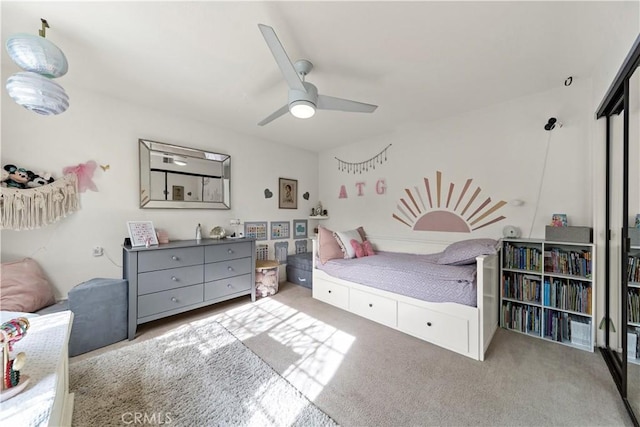 carpeted bedroom featuring ceiling fan and a closet