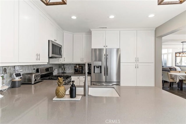 kitchen featuring white cabinetry, decorative backsplash, and appliances with stainless steel finishes