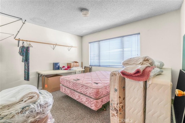 bedroom with carpet floors and a textured ceiling