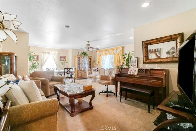 carpeted living room with ceiling fan with notable chandelier and a wealth of natural light