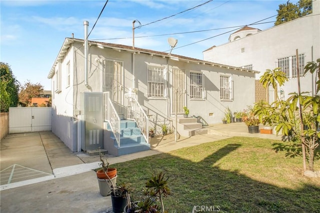 rear view of house featuring a lawn and a patio area