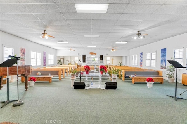 recreation room featuring a drop ceiling, ceiling fan, and carpet