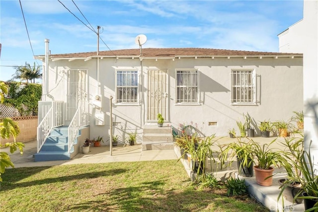 rear view of property featuring a lawn