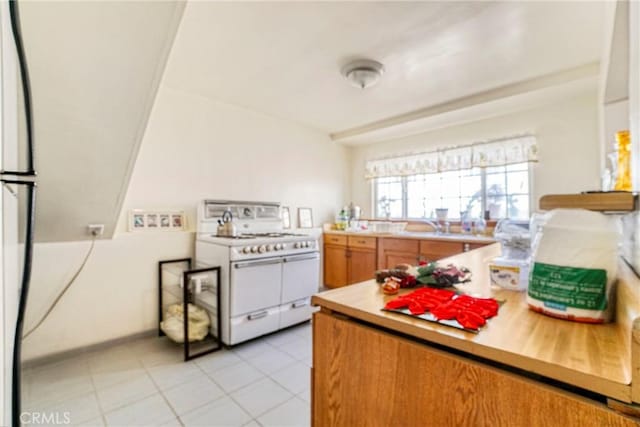 kitchen with range with two ovens and light tile patterned floors