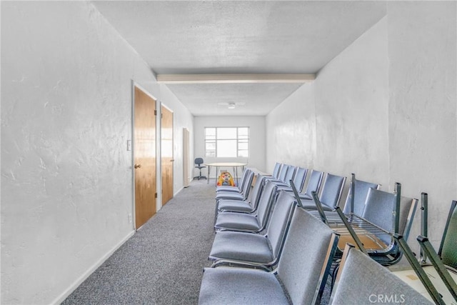 carpeted cinema featuring beam ceiling