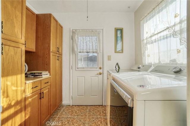 washroom with cabinets, washer and dryer, and light tile patterned flooring