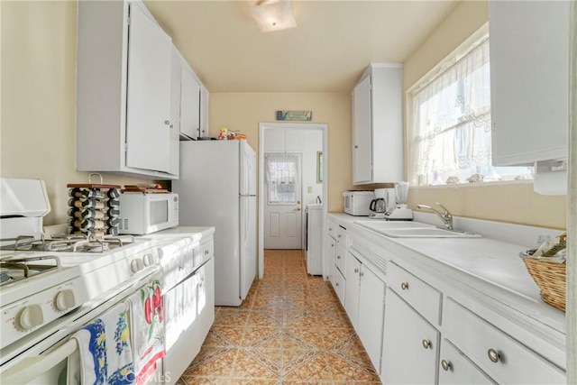 kitchen with sink, white cabinetry, light tile patterned floors, white appliances, and washer / clothes dryer