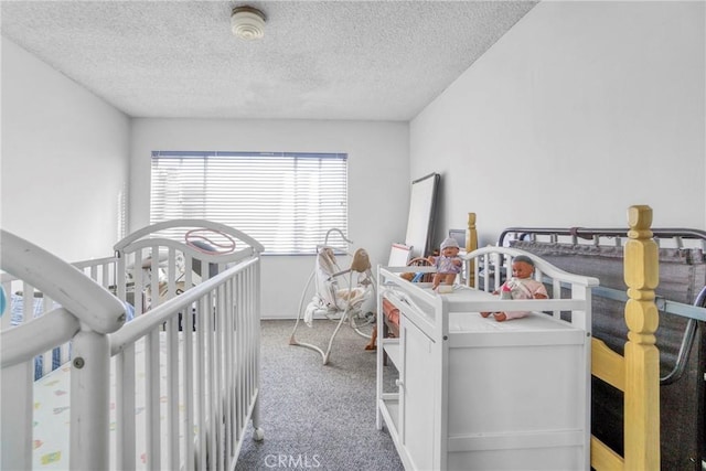 carpeted bedroom featuring a crib and a textured ceiling